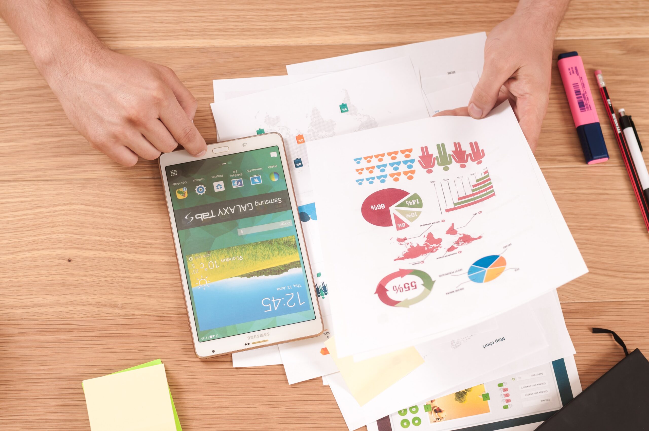 Person reviewing charts on paper and tablet